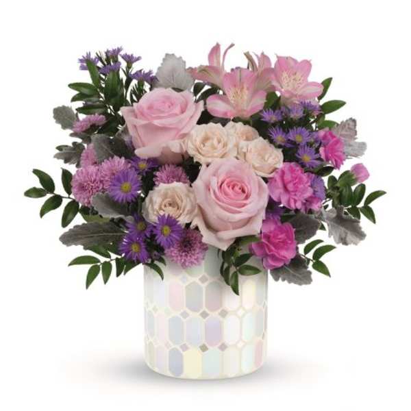 Pink roses and purple flowers in a patterned ceramic vase