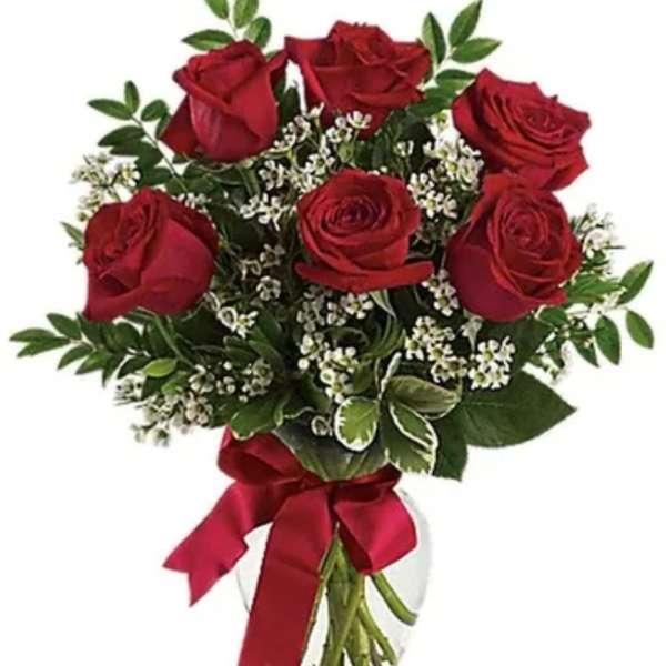 Bouquet of red roses with baby's breath in a clear glass vase