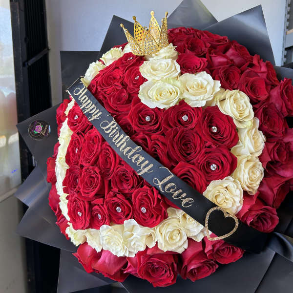 Red and white rose bouquet with a crown topper and birthday sash
