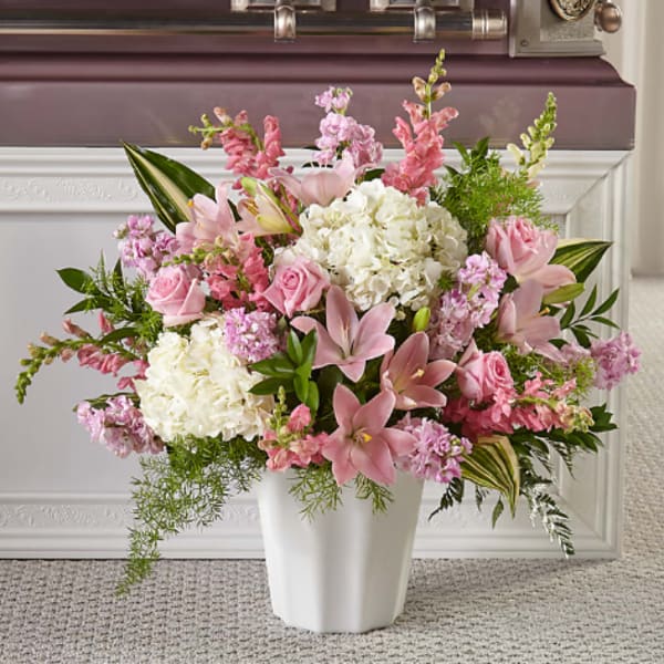 Pink and white floral arrangement in a white vase