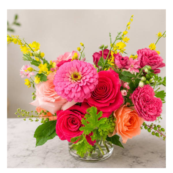 Pink and peach mixed flower bouquet in a clear glass vase