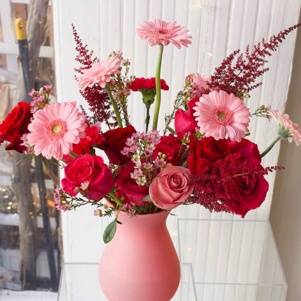 Pink and red mixed bouquet in a matte pink vase