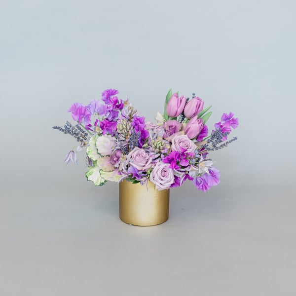 Lavender and pink bouquet in a gold cylinder vase