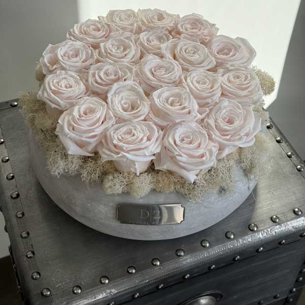 Round arrangement of pale pink roses in a silver box
