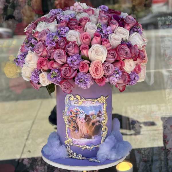 Large bouquet of pink, white, and lavender roses in a purple hatbox
