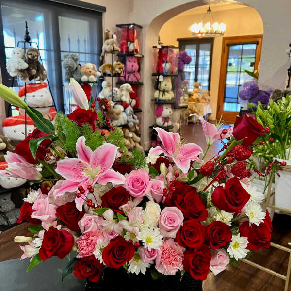 Large bouquet of red and pink roses with pink lilies in a black container