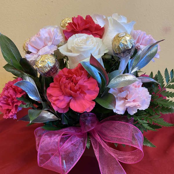 Bouquet of pink and white carnations with chocolate truffles and a pink ribbon