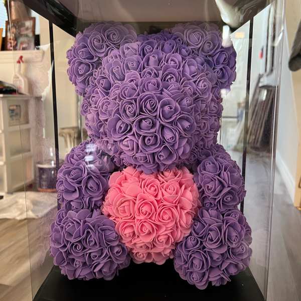Purple and pink teddy bear made of roses inside a clear display box