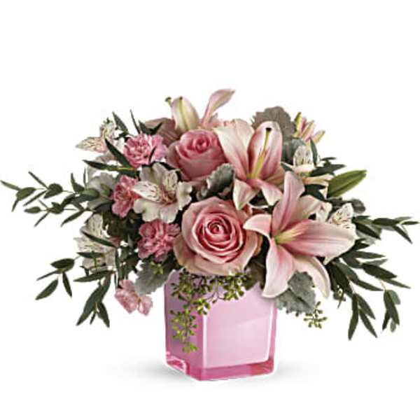 Pink roses and lilies arranged in a pink glass vase