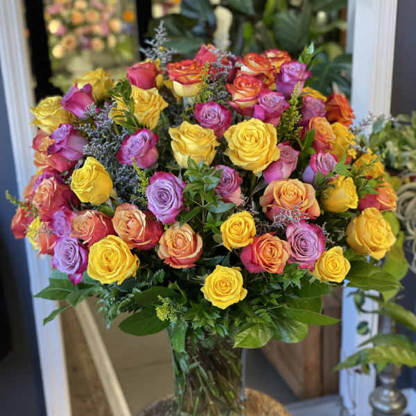 Bouquet of multicolored roses in a clear glass vase