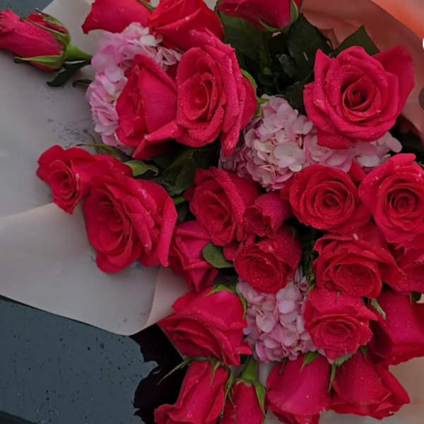 Bouquet of hot pink roses and pale pink hydrangea wrapped in paper
