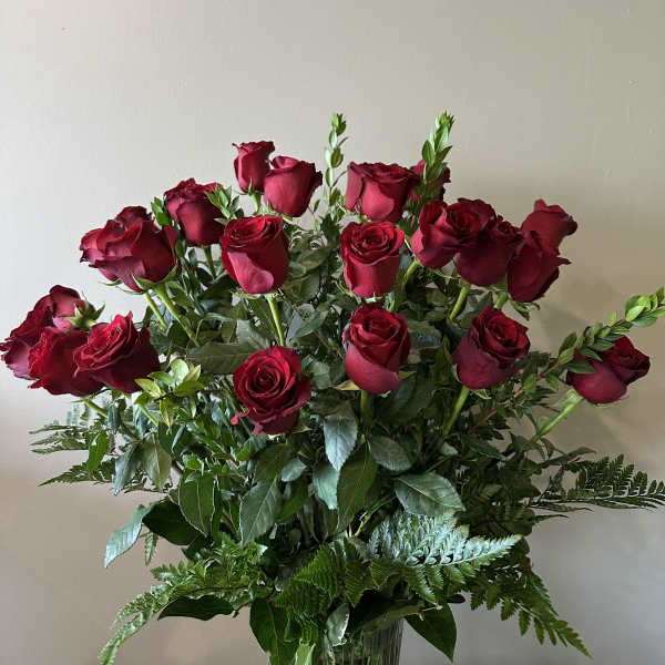 Bouquet of red roses with greenery in a clear vase