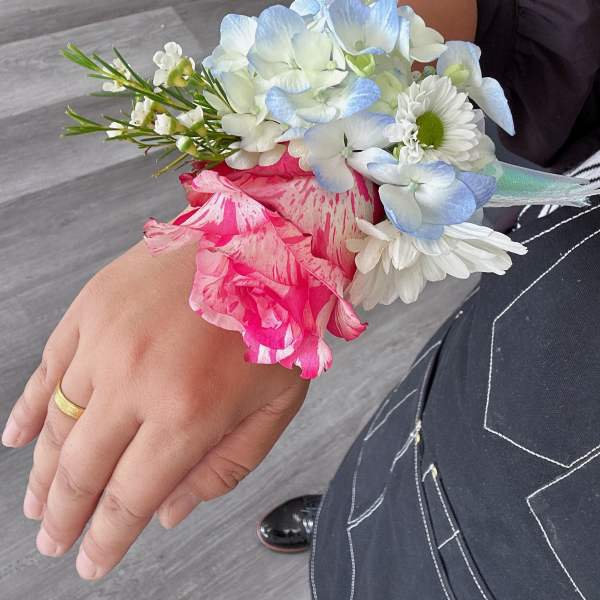 Wrist corsage with blue hydrangea, pink rose, and white daisies
