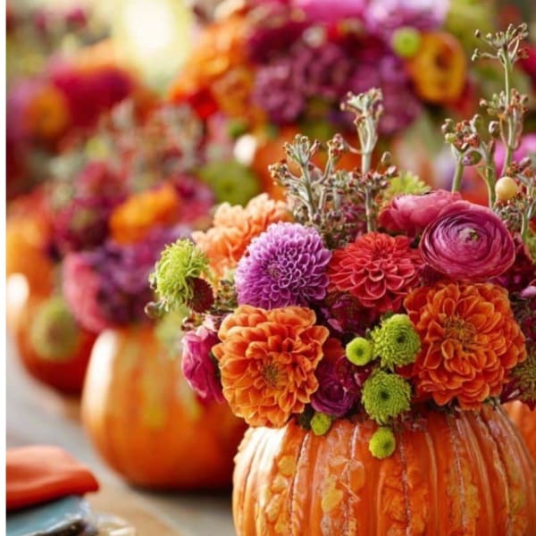 Colorful flower arrangement in a carved pumpkin vase