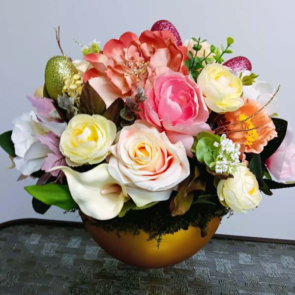 Silk arrangement of pastel roses, peonies, and calla lilies in a gold bowl with glitter accents.