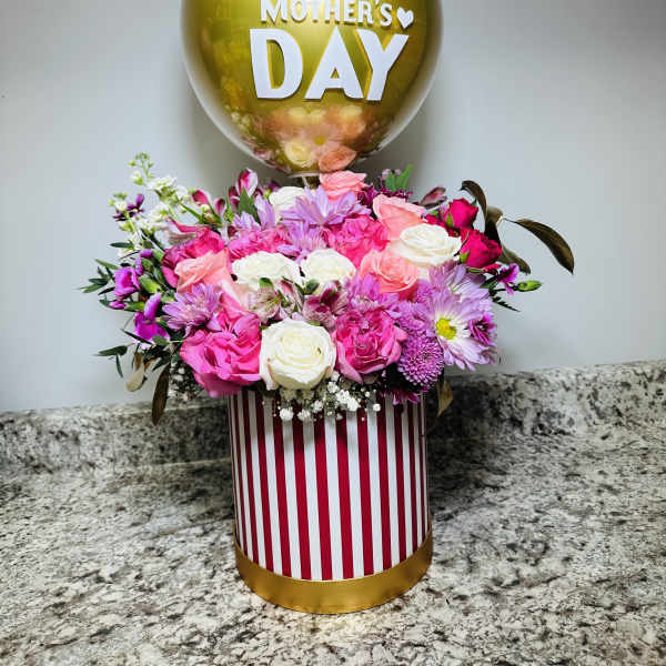 Pink and white flower arrangement with a gold Mother's Day balloon