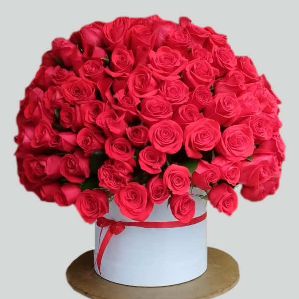 Large bouquet of red roses in a white hat box with a red ribbon