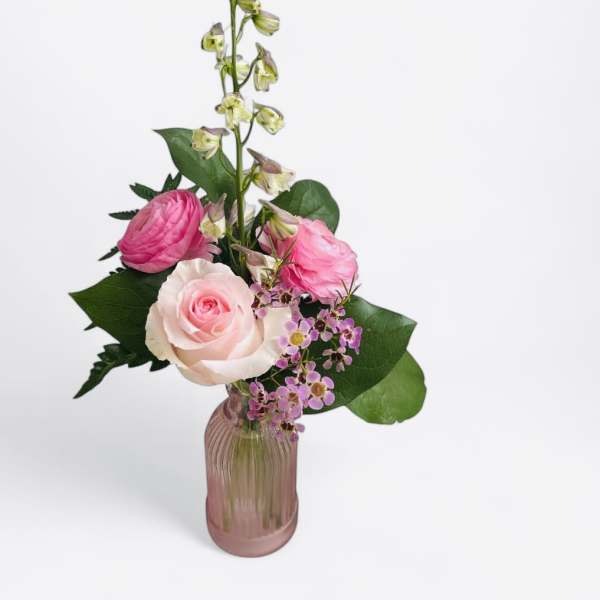 Pink and white roses in a pink glass vase