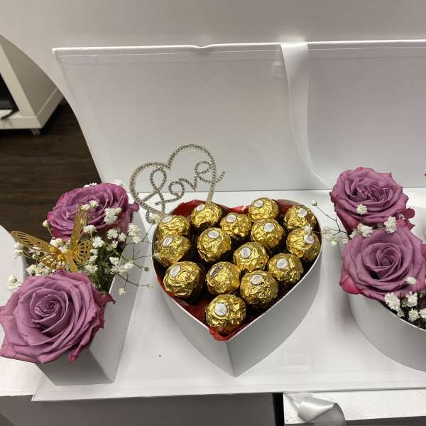 Heart-shaped gift boxes with purple roses and chocolates