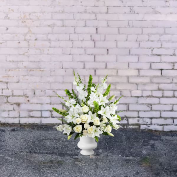 White floral arrangement in a white pedestal vase
