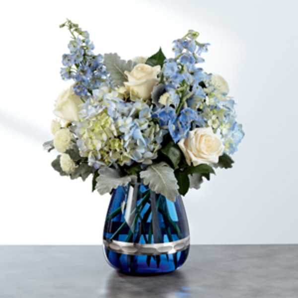 Blue and white flower arrangement in a cobalt glass vase