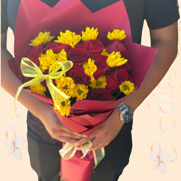 Bouquet of red roses and yellow daisies wrapped in burgundy paper