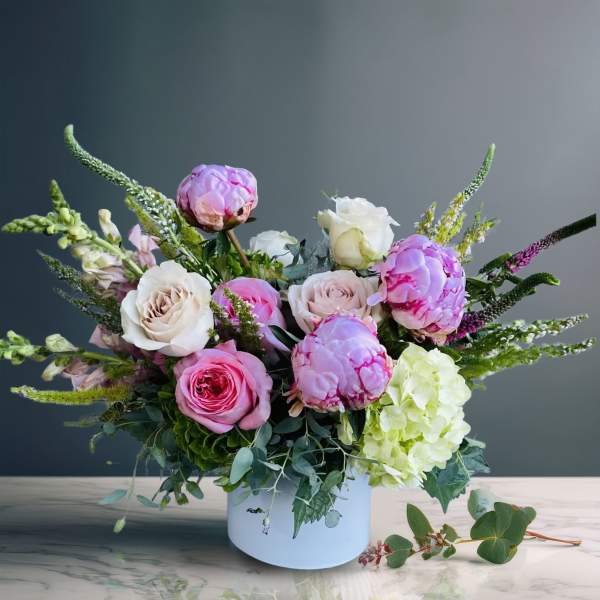 Pink and white roses with hydrangea in a white vase