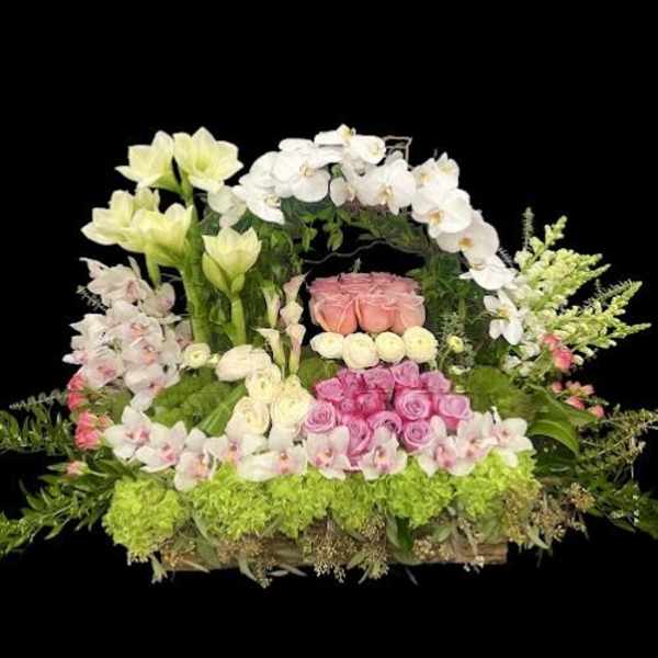 Large floral arrangement with pink and white flowers in a basket