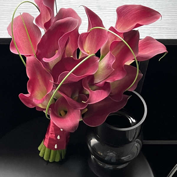 Bouquet of pink calla lilies with a black vase