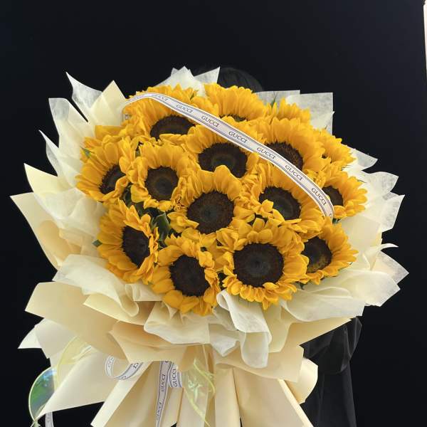 Bouquet of sunflowers wrapped in cream paper with a ribbon