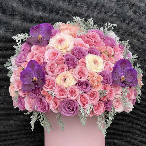 Pink and purple rose bouquet with orchids in a pink box