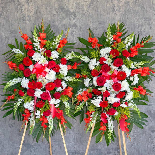 Two large standing floral sprays with red, white, and orange flowers