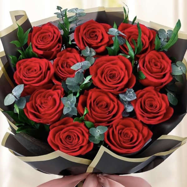Bouquet of red roses wrapped in black paper with a pink ribbon