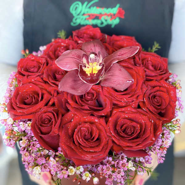 Red rose bouquet with a central orchid in a round box