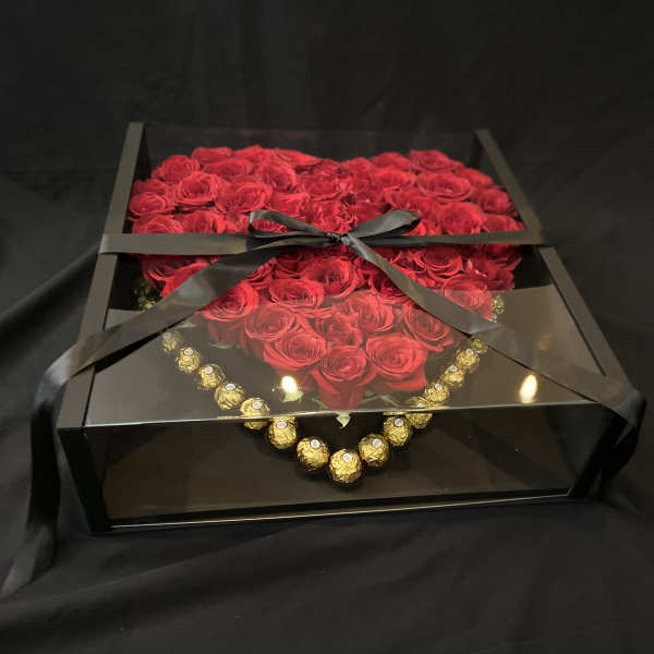 Box of red roses with a black ribbon and gold chocolates