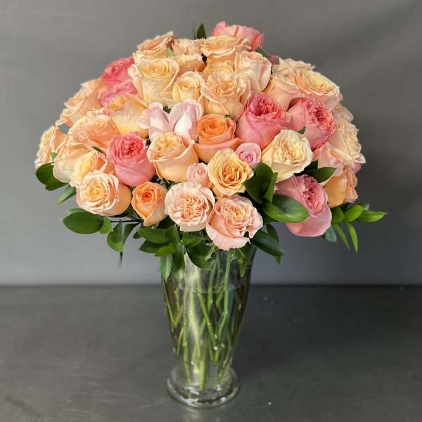 Bouquet of peach and pink roses in a clear glass vase