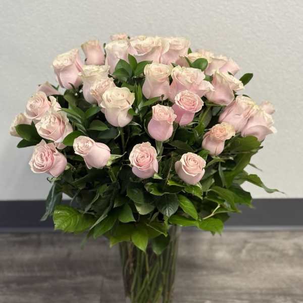 Bouquet of pale pink roses in a clear glass vase