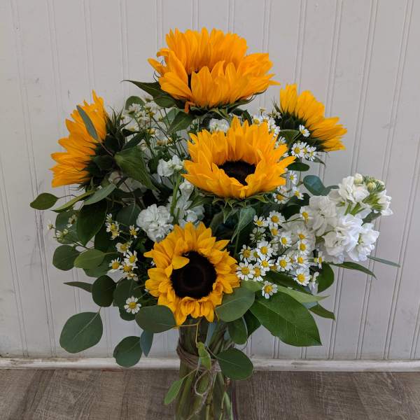Sunflower bouquet in a glass vase with white filler flowers