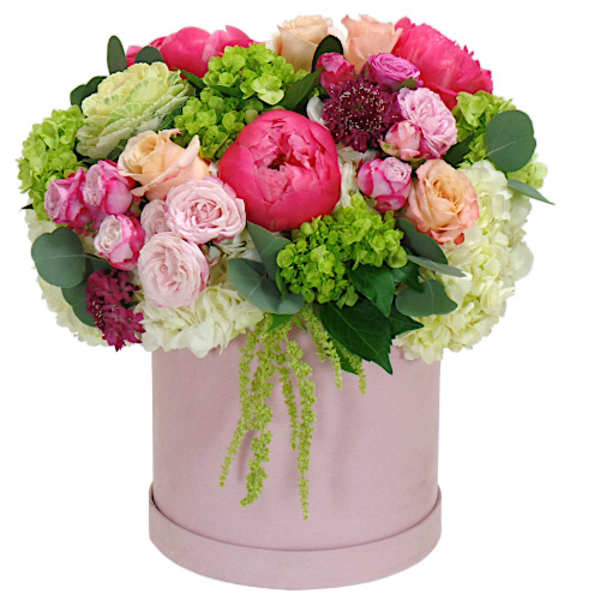 Pink and peach flower arrangement in a round blush box
