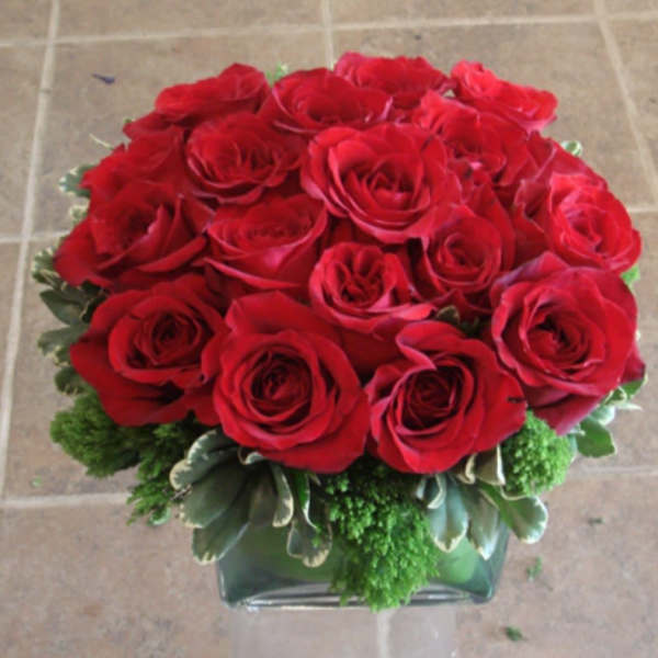Red roses arranged in a low glass vase