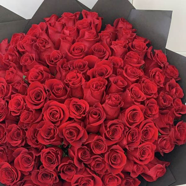 Large bouquet of red roses wrapped in black paper