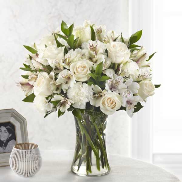 White roses and alstroemeria in a clear glass vase