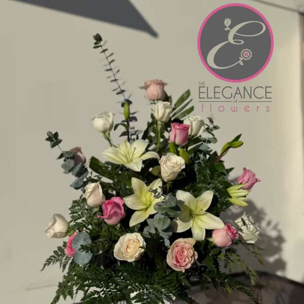 Tall bouquet of pink and white roses with lilies in a vase