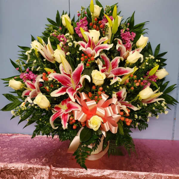 Large bouquet of pink lilies and cream roses with a satin ribbon