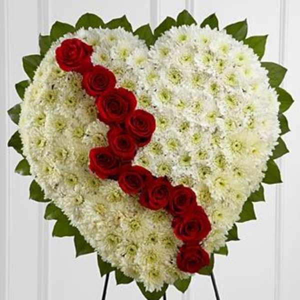 Heart-shaped floral spray with white flowers and a diagonal line of red roses