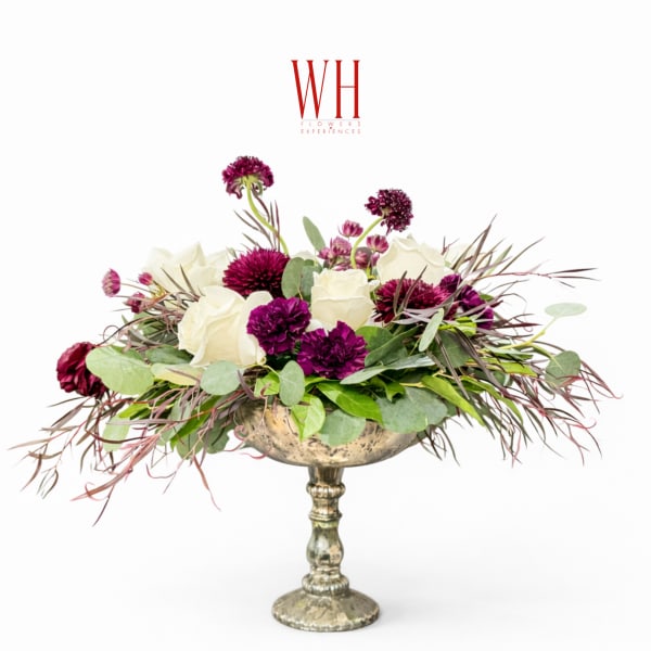 White and purple floral arrangement in a silver pedestal vase