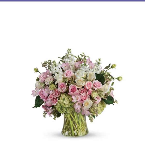 Pink and white rose bouquet in a clear glass vase