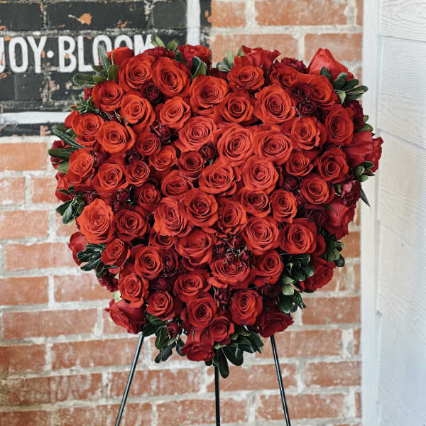 Heart-shaped arrangement of red roses on a stand