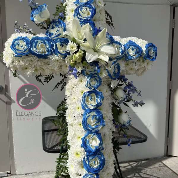 Large white floral cross with blue roses and white lilies