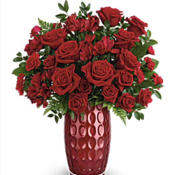 Red roses and red alstroemeria in a tall red vase